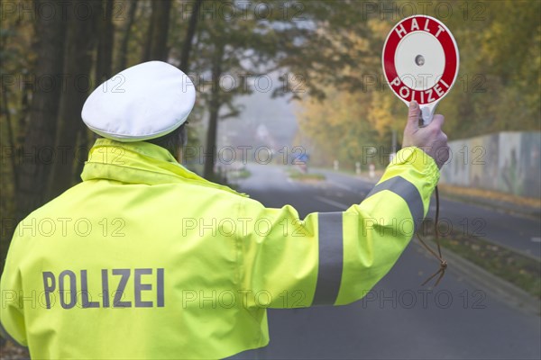 Policeman holding a signalling disc