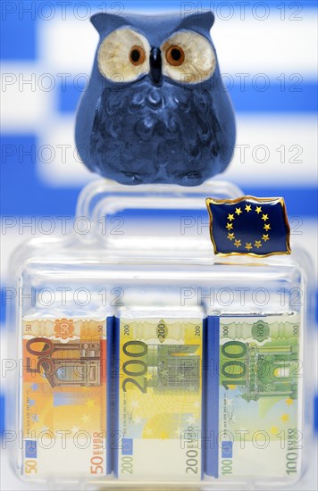 Owl on a suitcase full of money in front of a Greek flag