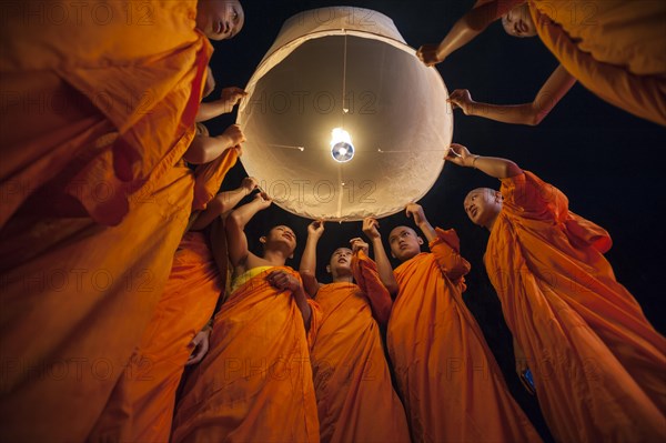 Monks releasing a Kongming lantern or sky lantern for luck during the Loi Krathong or Loy Gratong Festival