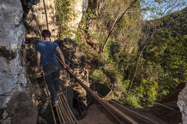 Woman walking on a bamboo bridge