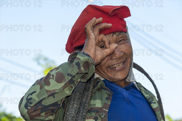 Man from the Shan or Thai Yai ethnic minority imitating a camera by holding his fingers in front of his face