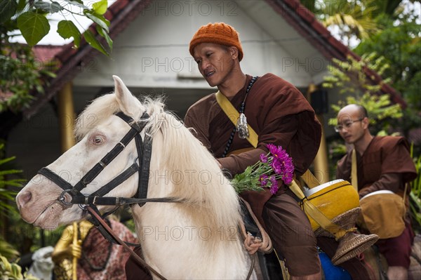 Buddhist monk on horseback collecting alms in the morning