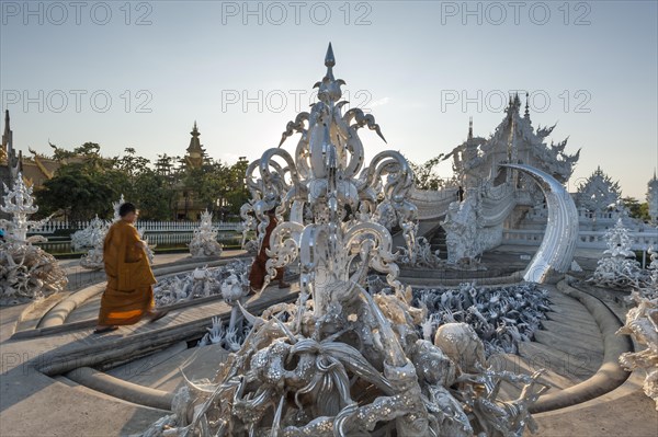 Buddhist monk walking across a bridge