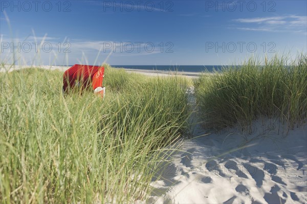 Dunes and red roofed wicker beach chair