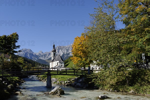 Parish Church of Saint Sebastian and the Ramsau river in front of the Reiteralpe or Reiter Alm mountains