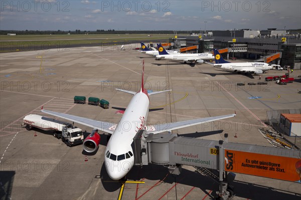 Airplane attached to a jetway or passenger boarding bridge on the airport apron