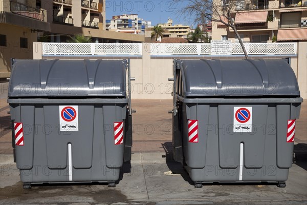 Wheeled trash cans standing on the roadside