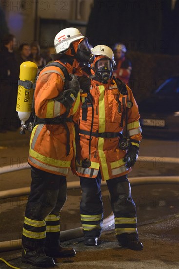 Two firefighters on site at an apartment fire