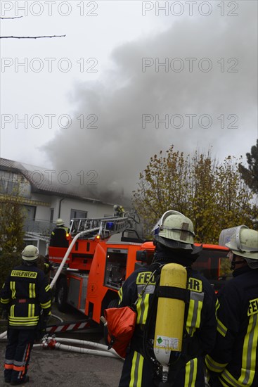 Firefighters wearing breathing equipment while extinguishing a roof fire