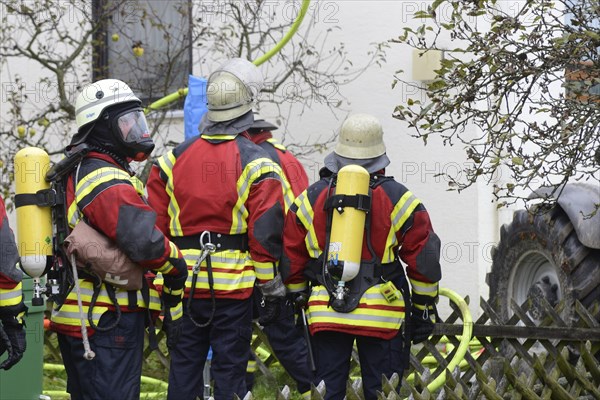 Firefighters wearing breathing equipment while extinguishing a roof fire