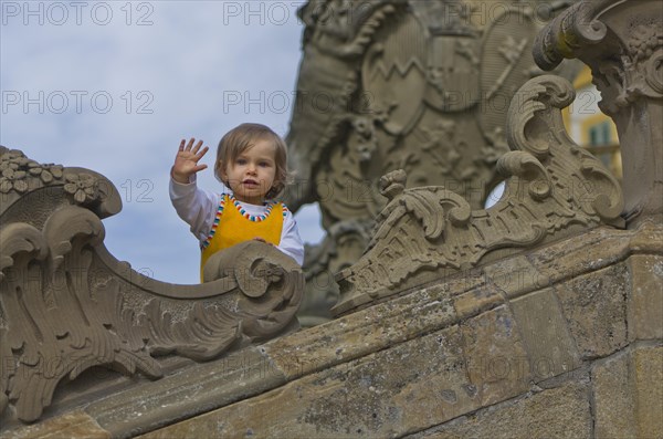 Little girl at the stone sculptures in the park around Schloss Seehof palace