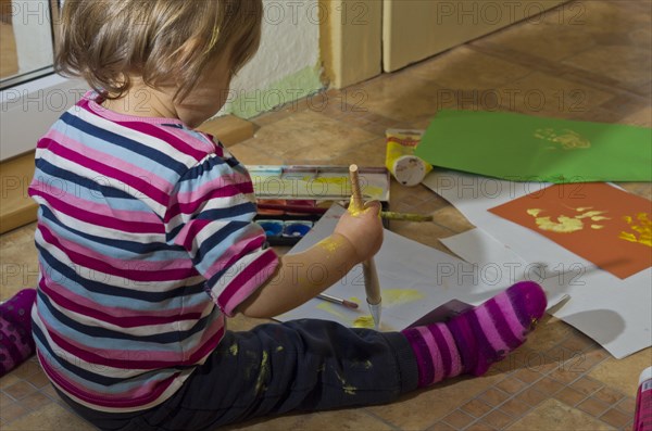 Little girl painting with acrylic paint