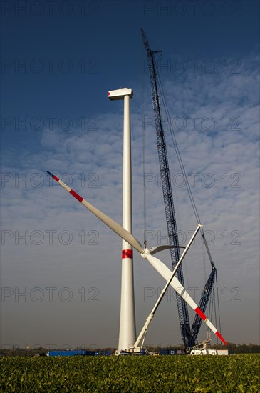 Crane lifting the rotor blades of a new wind turbine