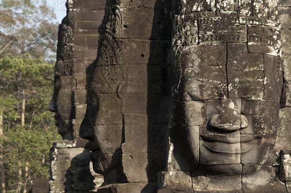 Large sculptures of heads on tower of Khmer temple