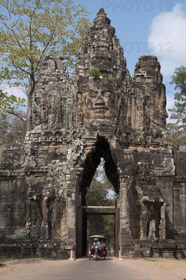 Rickshaw going through gate tower at Khmer temple