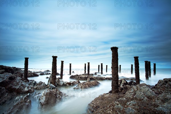 Steel stantions of ruined Victorian pier visable on shore at low tide