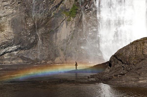 Angler in front of the waterfall