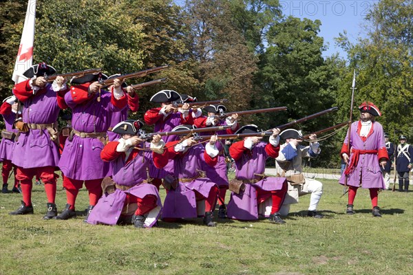 Soldiers with muzzle-loading rifles shooting during live role-playing or ReenLarpment