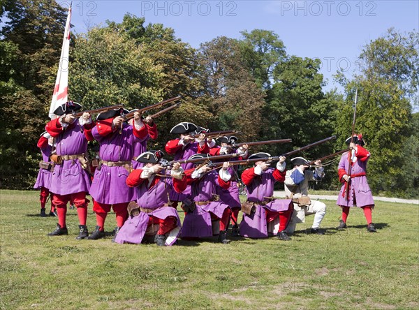 Soldiers with muzzle-loading rifles shooting during live role-playing or ReenLarpment