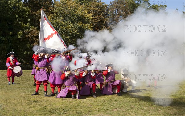 Soldiers with muzzle-loading rifles shooting during live role-playing or ReenLarpment