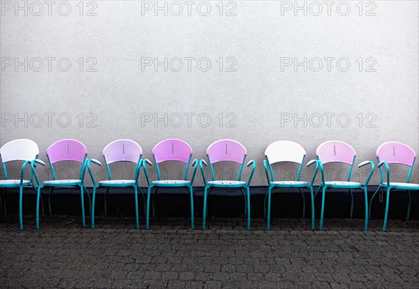 A row of pink chairs in front of an Italian ice cream parlor