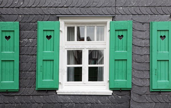 House front with slate and with a heart in the shutters