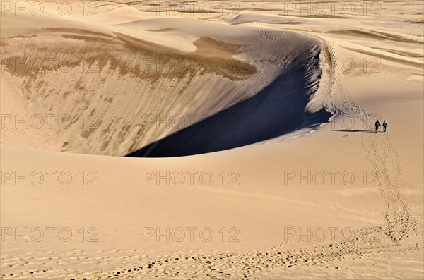 Hikers leaving tracks in the sand