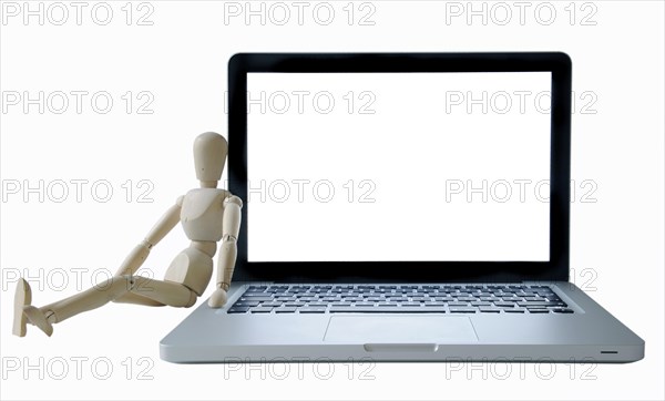 Manikin leaning against a laptop computer