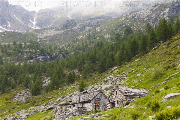 Man arriving at a few mountain huts while hiking
