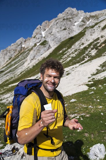 Hiker reapplying sunscreen