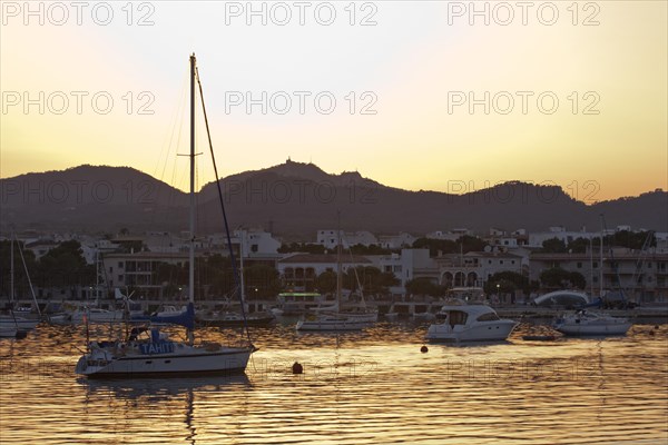 Sailing boats in a harbour at sunset