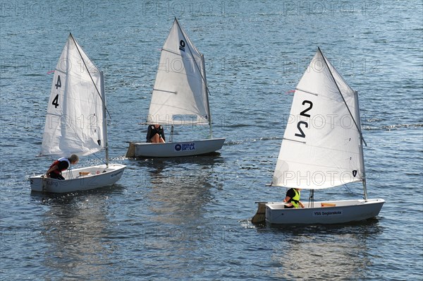 Three Optimist dinghies in a sailing school