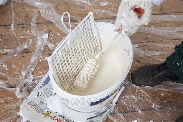 Bucket of paint with a paint roller for painting the walls