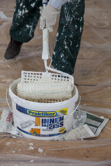 Bucket of paint and a paint roller for painting the walls