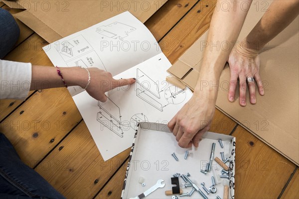 Mother and daughter working together to assemble a bed in the daughter's room