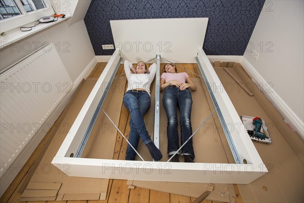 Mother and daughter working together to assemble a bed in the daughter's room