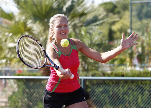 Young woman playing tennis in a holiday club