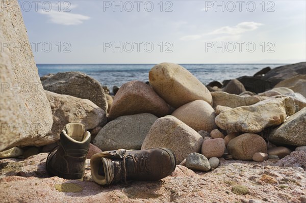 Hiking shoes lying on the beach of Mari Pintau