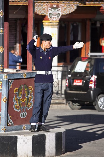 Policeman regulating traffic at traffic light free main crossing