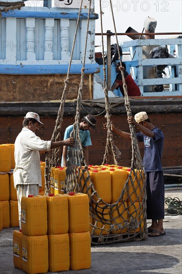 Loading cargo on an old wooden cargo ship