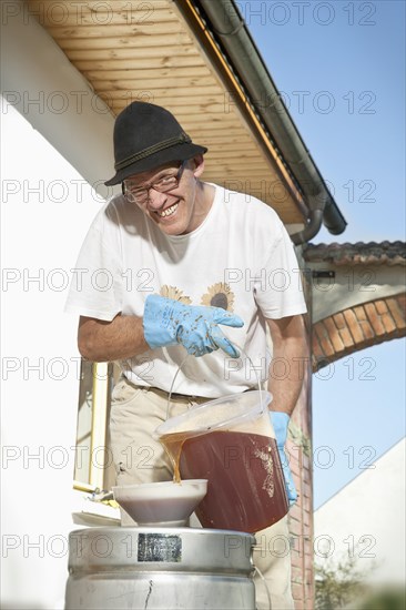 Man filling apple juice into a pressure barrel