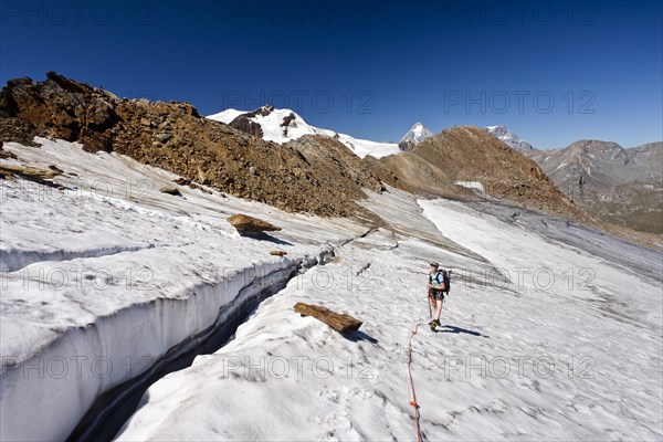 Hiker climbing to the peak of Cima Venezia mountain