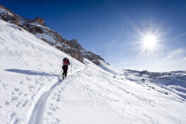 Cross-country skier ascending Zendleser Kofel Mountain in Villnoesstal valley