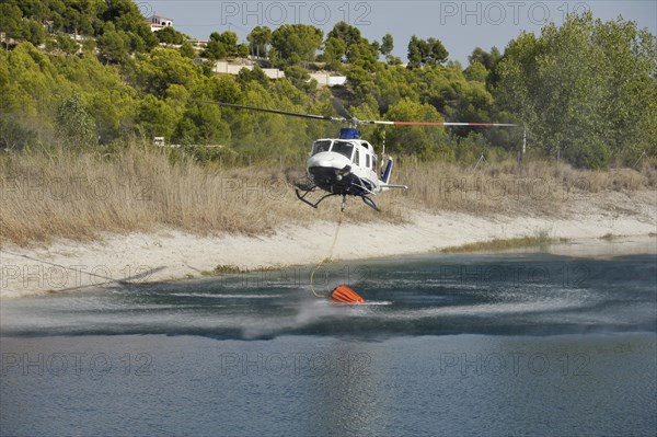 Fire helicopter getting water from a small artificial lake near Altea La Vella