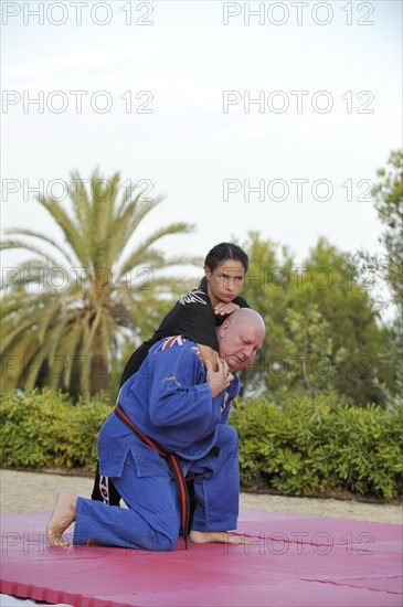 Woman and a man doing martial arts training in a park