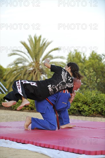 Woman and a man doing martial arts training in a park