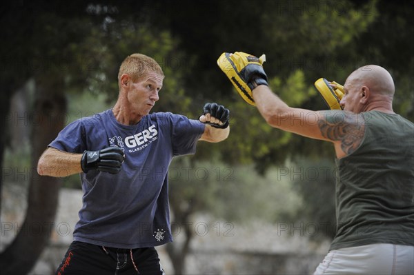 Two men doing martial arts training in a park