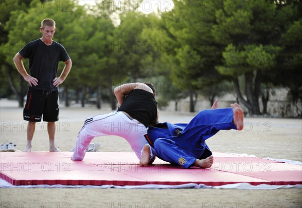 Two men doing martial arts on a mat