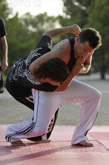 A man and a woman doing martial arts in a park