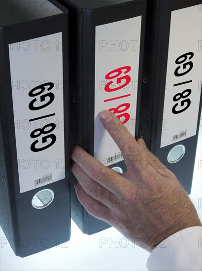 Hand reaching for a file folder labeled 'G8 - G9'